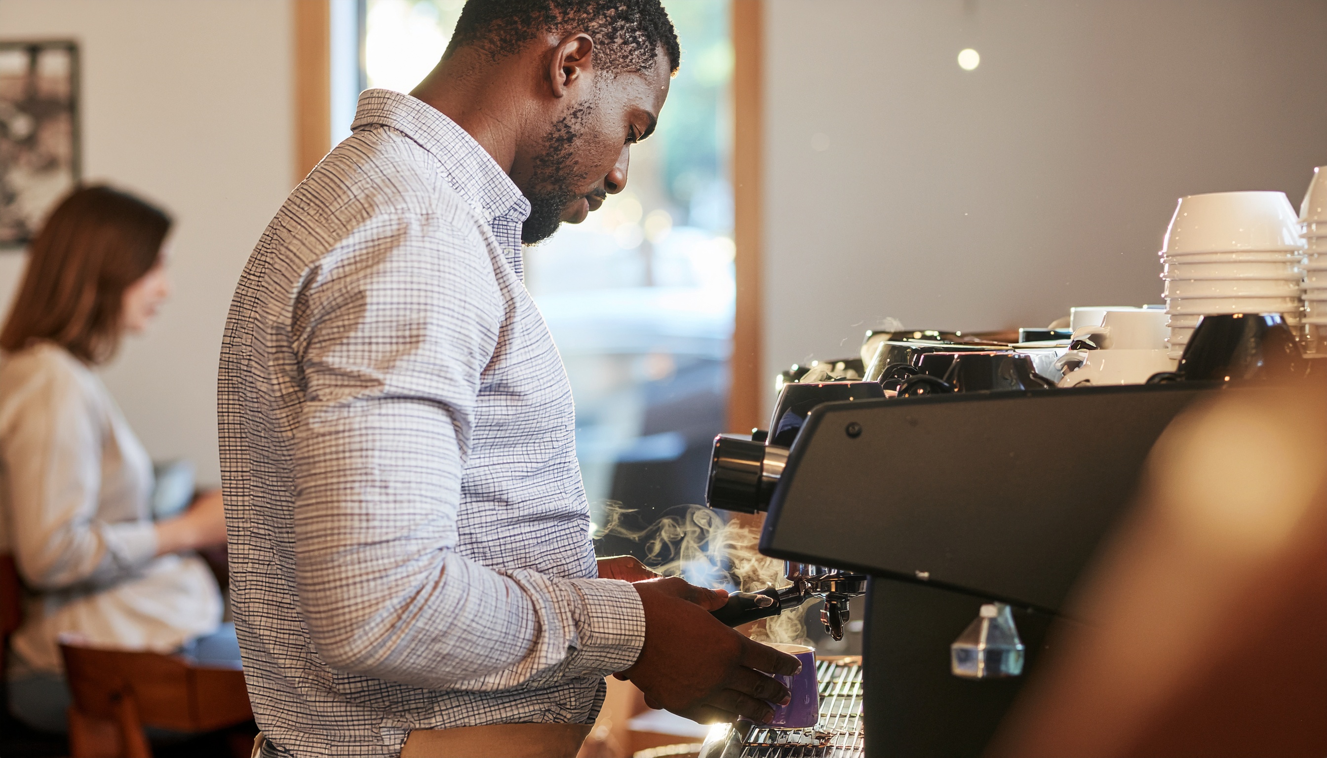 Focused Barista Brewing Coffee with Modern Espresso Machine